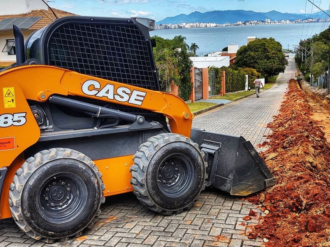 Minicarregadeira CASE SV185 abrindo vala em rua